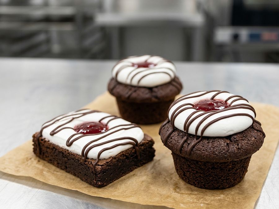 Chocolate muffins and a brownie topped with marshmallow, jam and chocolate drizzle