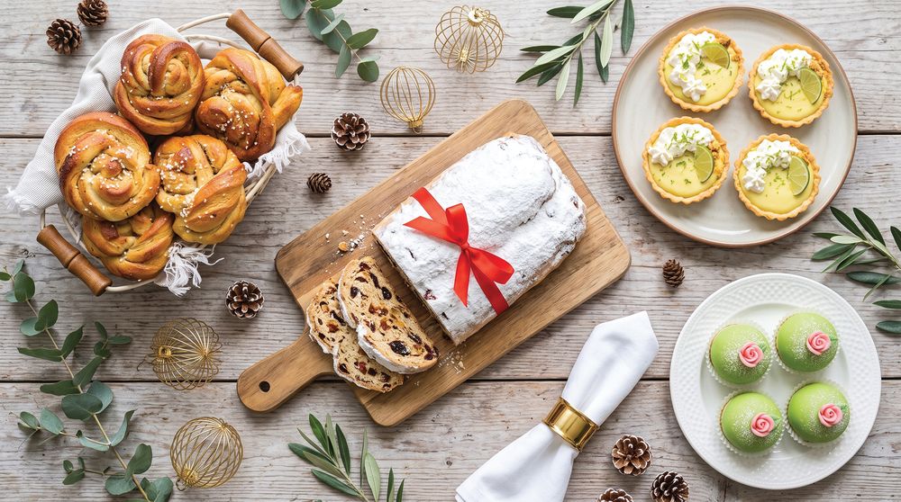 Stollen, cardamom knots, key lime tarts and princess cakes on a timber table